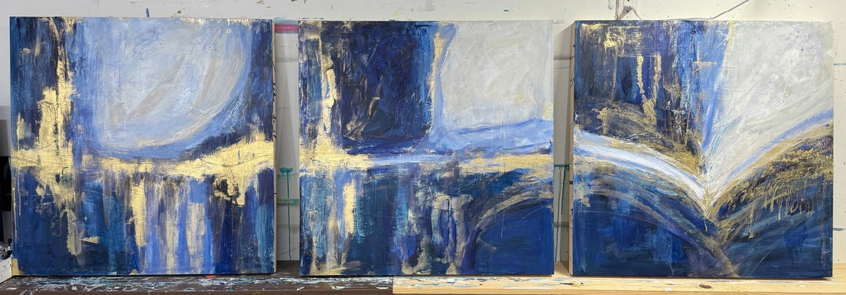 Three blue and gold abstract paintings photographed together in the studio.