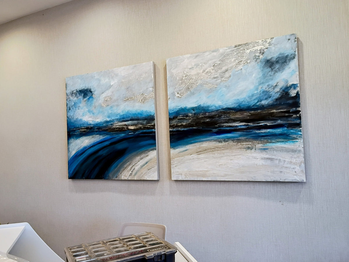 A pair of blue and white abstract landscape paintings installed together.