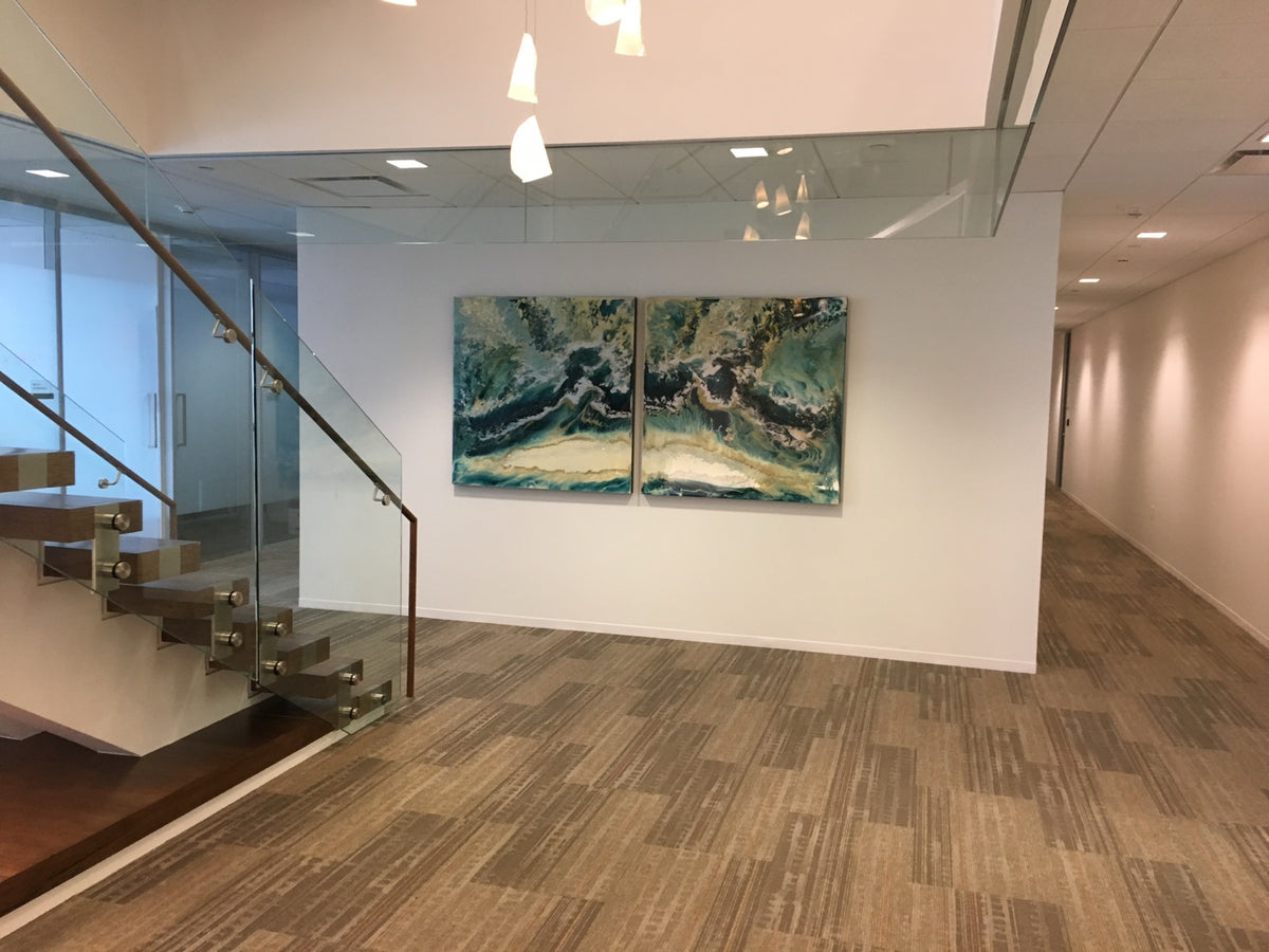 Two teal and cream abstract paintings by Blakely Bering beside a glass stairwell.