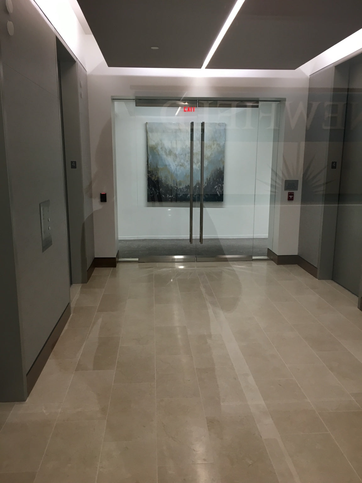 A large pale blue and charcoal painting viewed through glass doors in an elevator lobby.