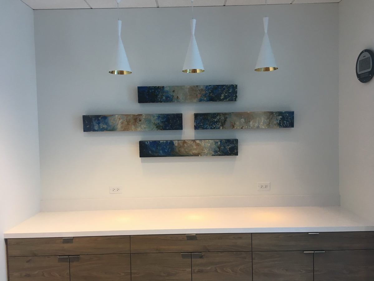 Four blue and gold horizontal abstract panels in a staggered wall arrangement.