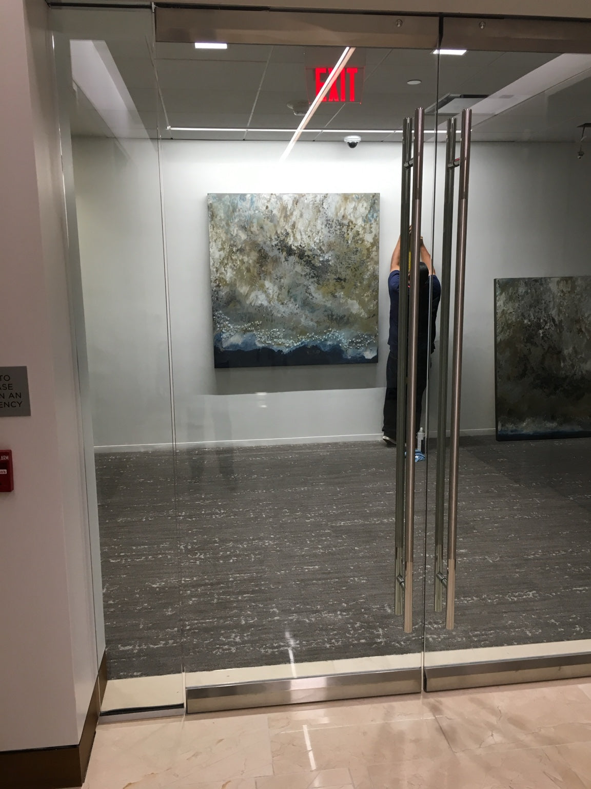 An abstract painting being positioned during an installation.
