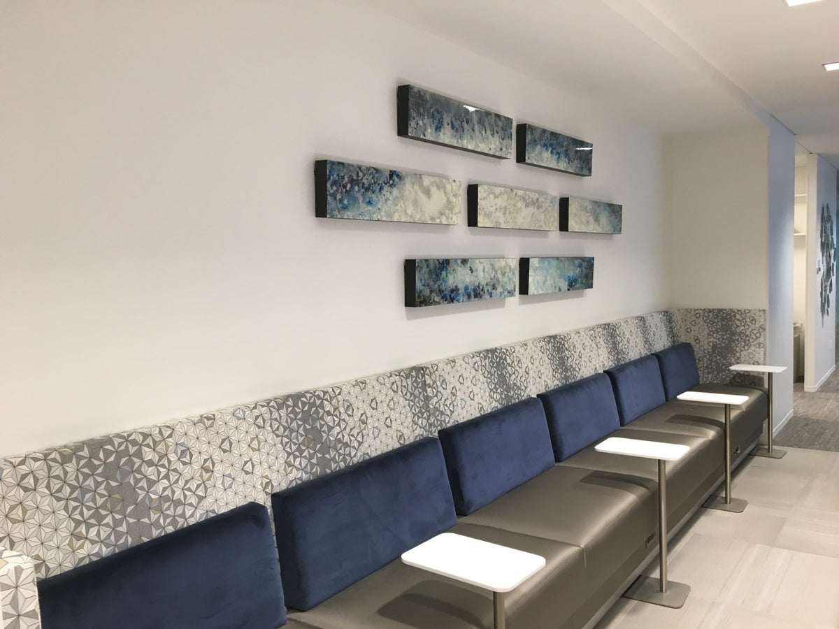 Seven blue and cream horizontal panels arranged above banquette seating.