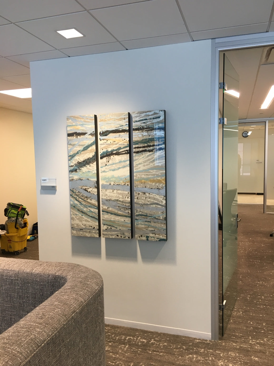 Three teal, cream, black, and gold linear abstract panels in a shared interior.